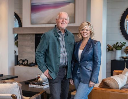 Rich and Leslie Frank standing in front of the fireplace inside the Miller House