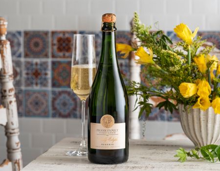 Frank Family's Lady Edythe Reserve Brut set next to a wine glass and some flowers