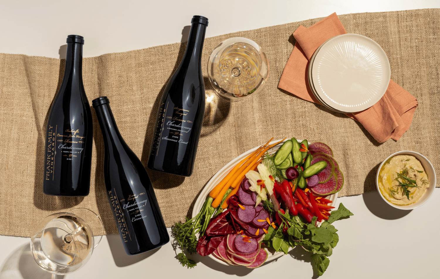 Frank Family's reserve Chardonnays displayed next to a Spring vegetable spread.