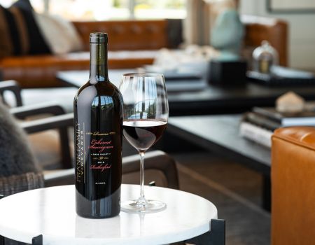 A bottle 2018 RHF Cabernet perched on an end table in the Miller House