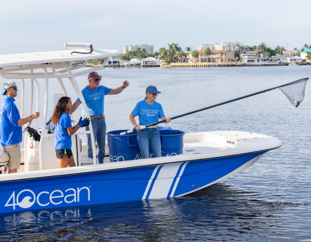 Leslie Frank pulls trash from the ocean while on the 4ocean boat.