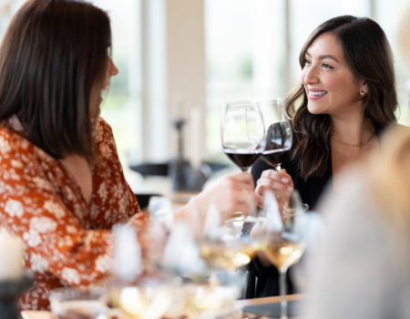 Two guests cheersing with glasses of Frank Family Vineyards Pinot Noir.