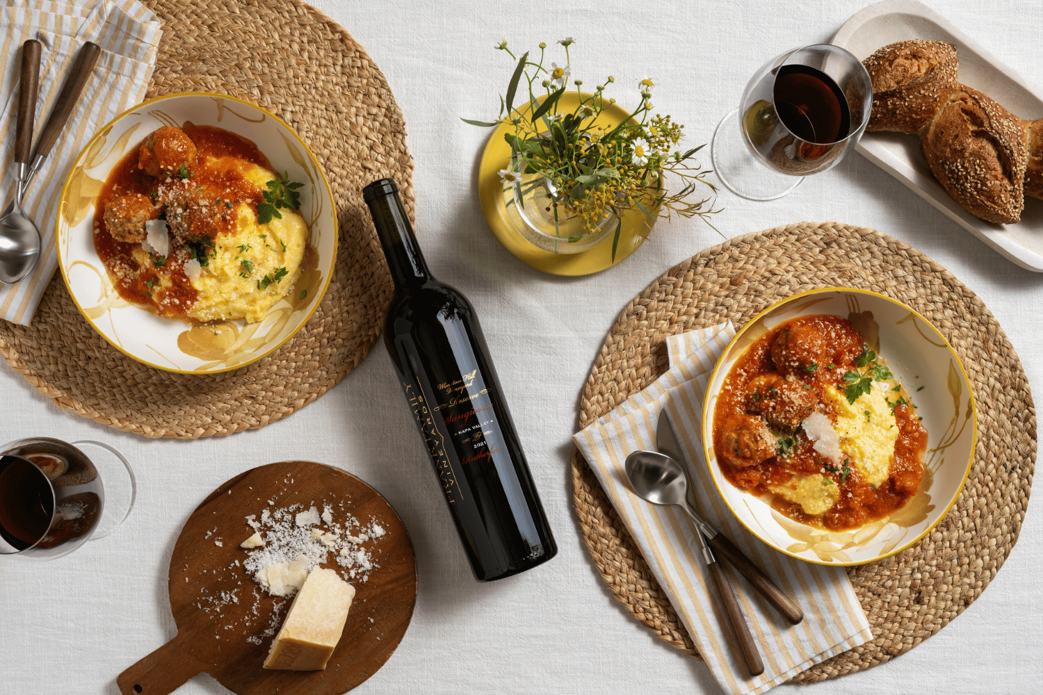 An overhead shot of a bottle of Frank Family's Winston Hill Sangiovese alongside dishes of polenta and meatballs. 