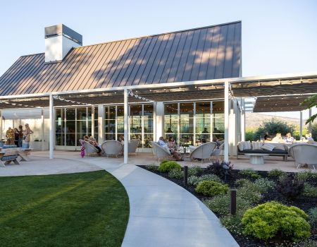 Exterior of the Miller House with guests enjoying the patio and lounge seating